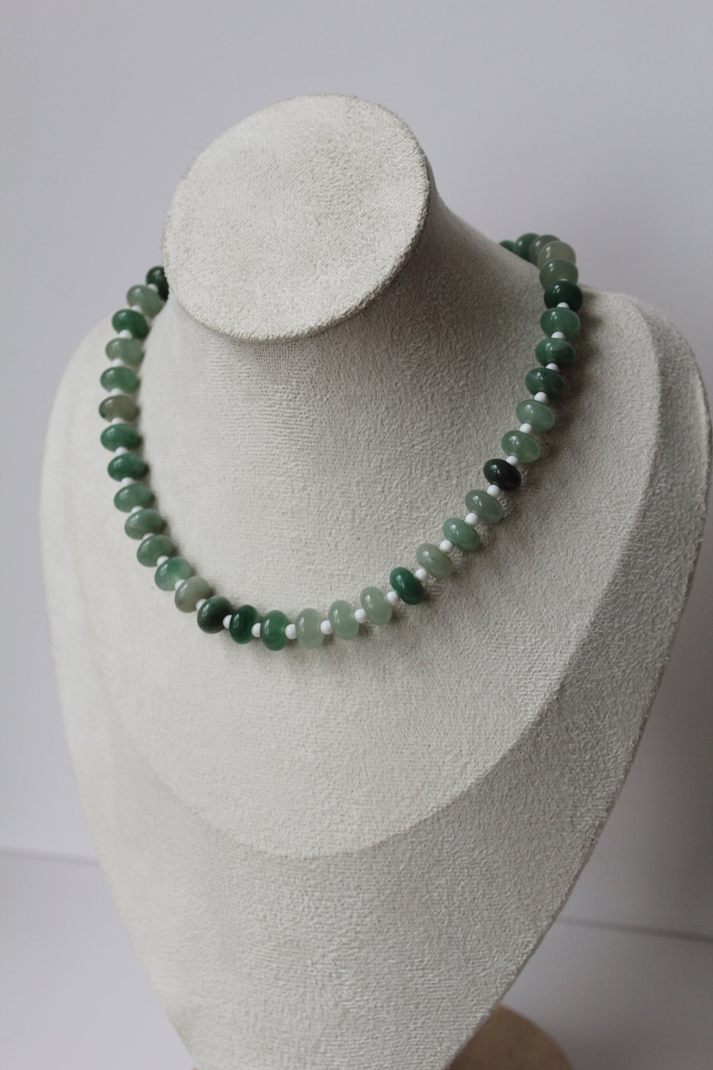 Green beaded Sea Glass Necklace displayed on a jewelry bust.