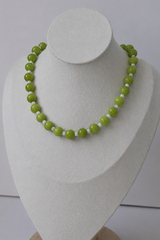 Lime green and white beaded necklace displayed on a jewelry bust.