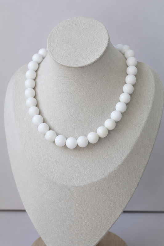 Handcrafted white acrylic beaded necklace displayed on a jewelry bust.