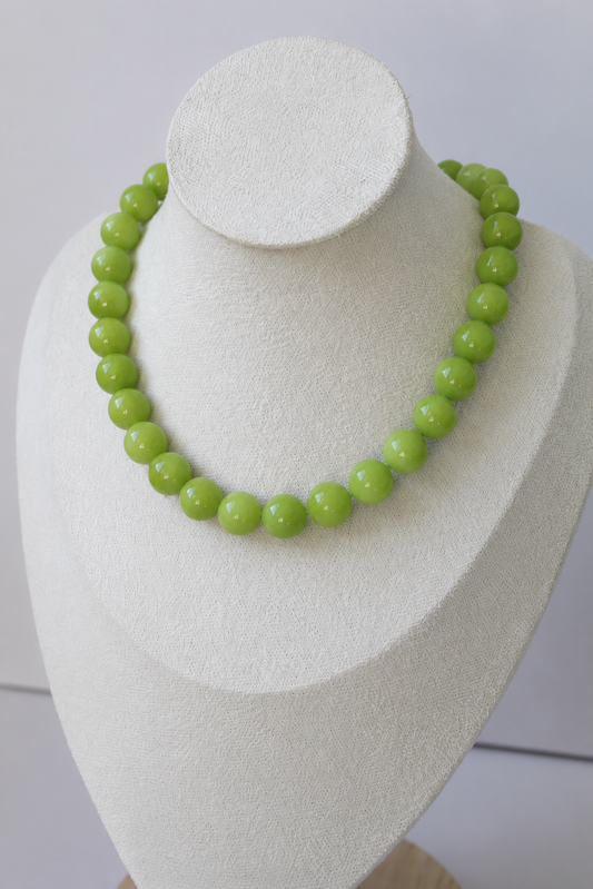 Handcrafted lime green acrylic beaded necklace displayed on a jewelry bust.
