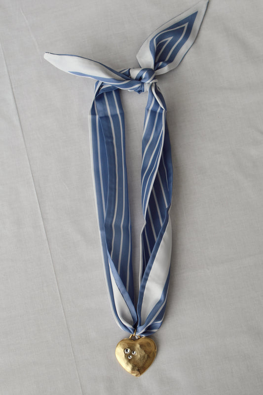 Gold heart pendant with crystal details on blue striped scarf necklace