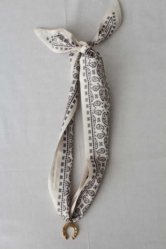 Lucky Ivory scarf necklace with ivory and black print and gold horseshoe pendant