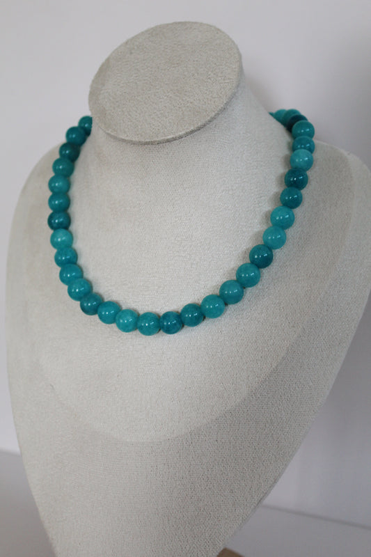 Handcrafted turquoise acrylic beaded necklace displayed on a jewelry bust.