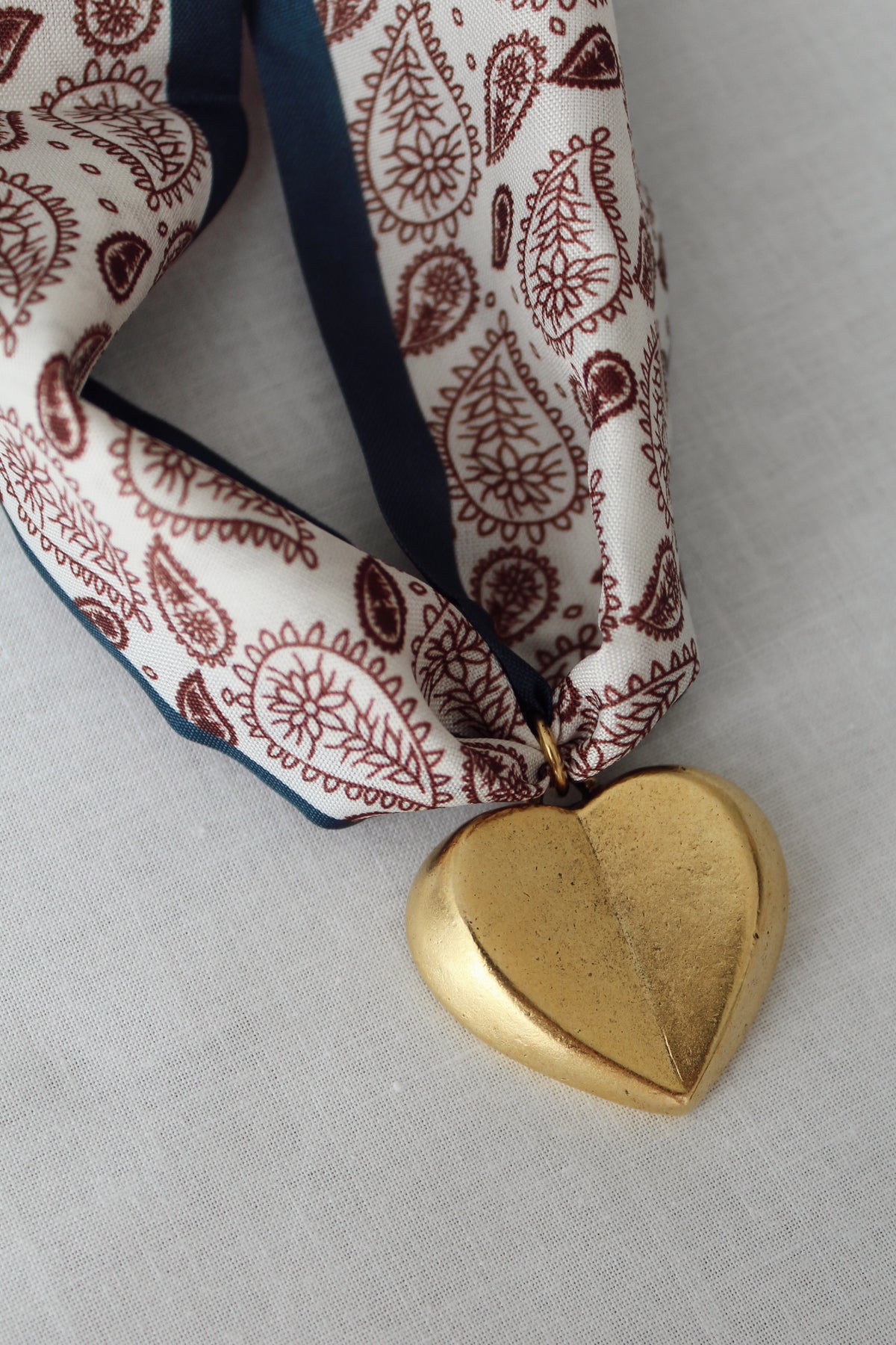 Gold heart pendant on cream chocolate brown and navy scarf necklace