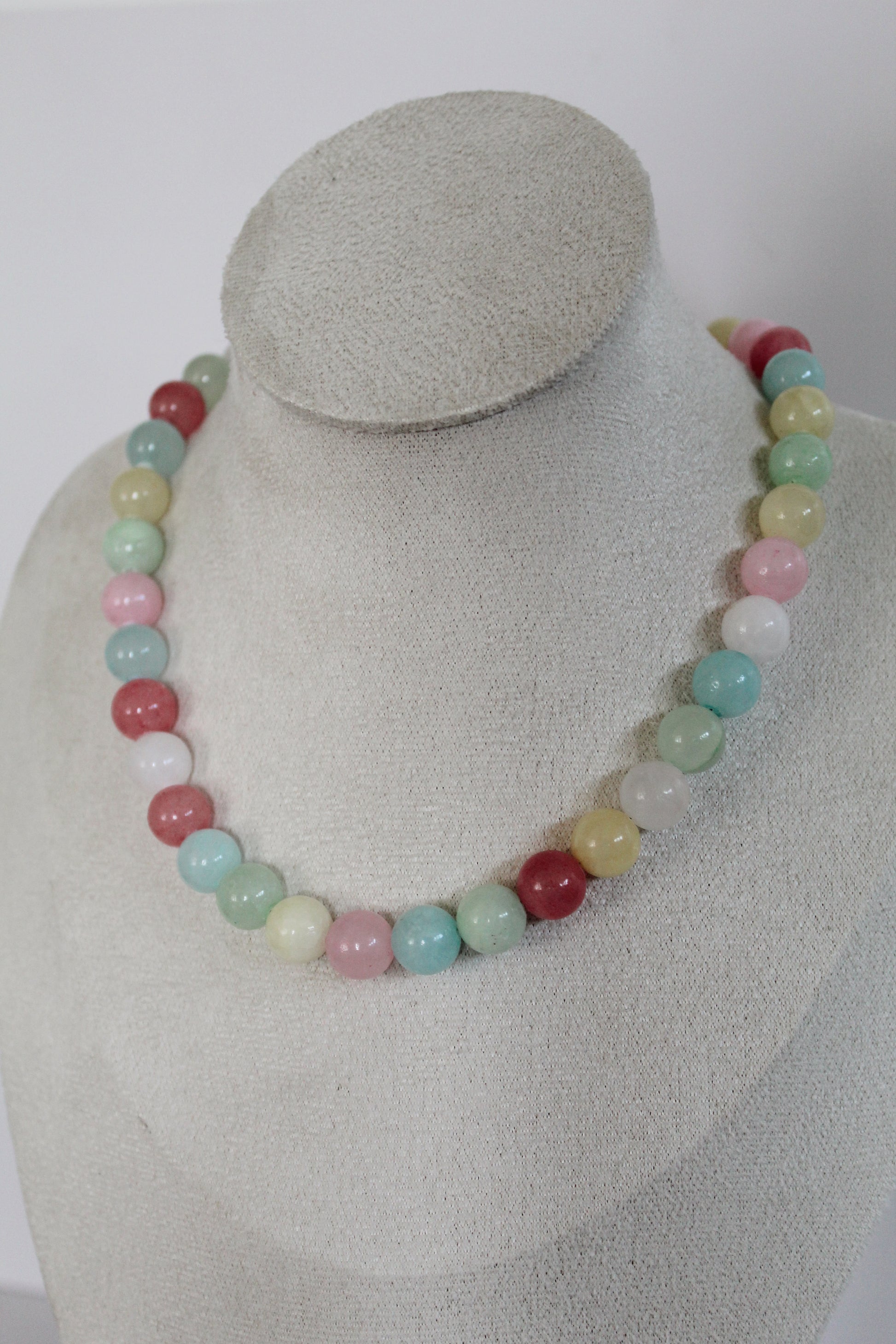 Handcrafted pastel acrylic beaded necklace featuring pink, mint, aqua, butter yellow, cream, and berry-colored beads displayed on a jewelry bust.