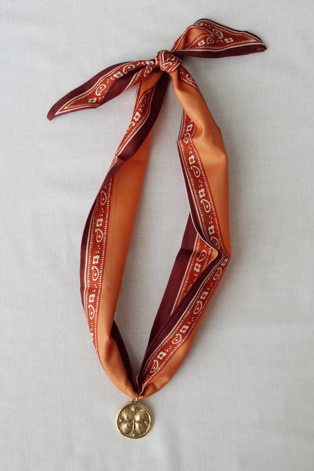 Harvest Bloom rust and orange scarf necklace with gold floral pendant