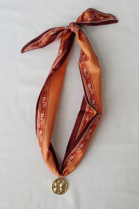 Harvest Bloom rust and orange scarf necklace with gold floral pendant