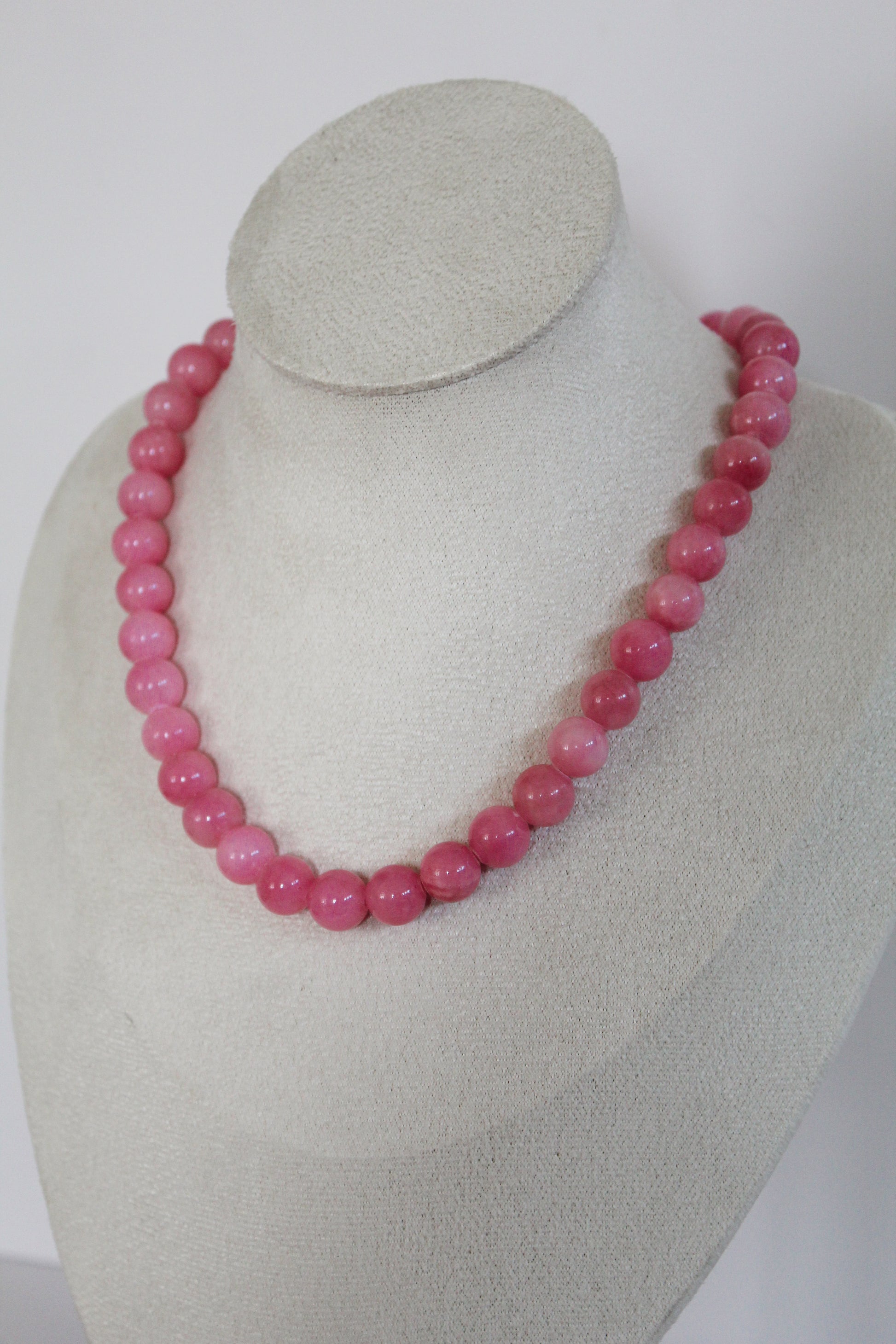 Handcrafted orchid pink acrylic beaded necklace displayed on a jewelry bust.