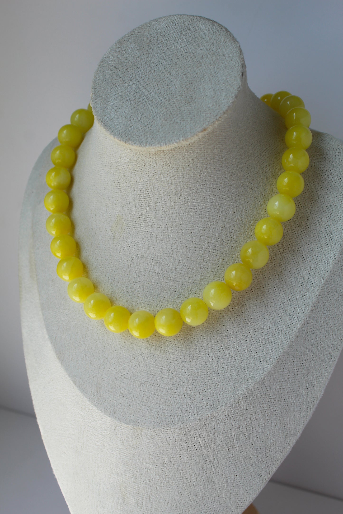 Lemon Drop yellow beaded necklace on cream jewelry display