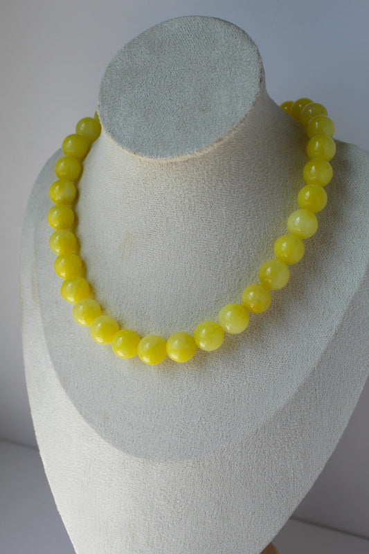 Lemon Drop yellow beaded necklace on cream jewelry display